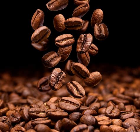 Premium Photo | Falling coffee beans on dark background