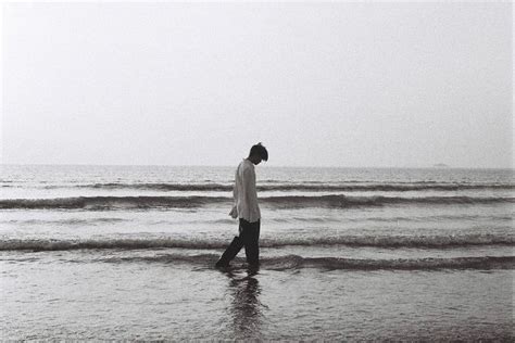 A Man Is Walking In The Water At The Beach