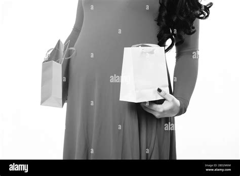 Female Hands Of Pregnant Woman Holding Colorful Package Or Bags In Red Dress Isolated On White