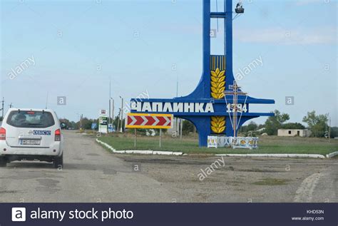 Street Sign ”chaplinka” And A Car Of Mission Of Osce On A Road Chaplinka Town Near The Border