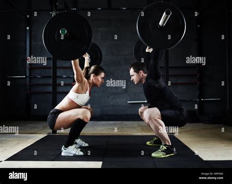 Motivational Side View Image Of Young Man And Woman Performing Overhead