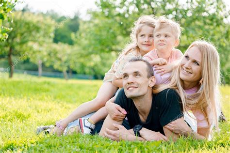 Familia joven tendida en la hierba en el campo fotografía de stock