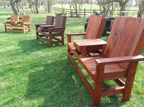 Several Wooden Chairs Sitting On Top Of A Lush Green Field