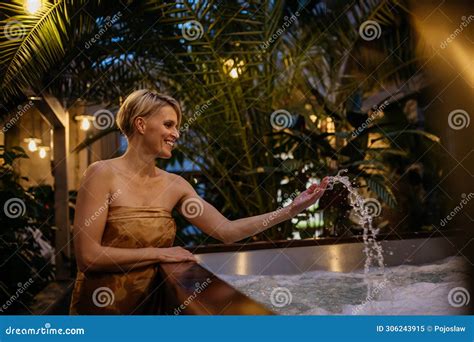 Beautiful Woman Standing By Hot Tub Splashing Water Enjoying Wellness Weekend In Spa Stock