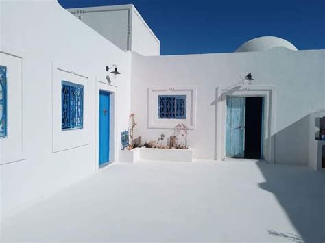 A White House With Blue Doors And Windows