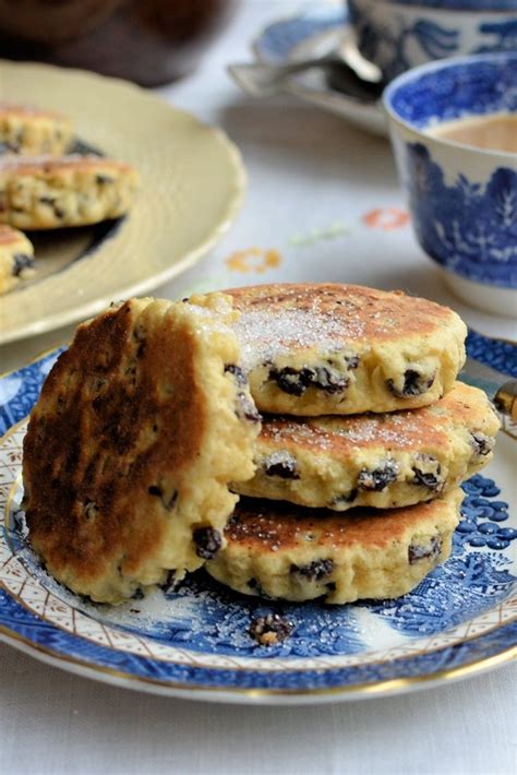 Blueberry Pancakes Stacked On Top Of Each Other In Front Of A Cup Of Coffee