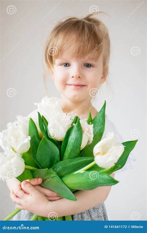 Menina Bonita Que Guarda Um Ramalhete Das Flores Foto De Stock Imagem