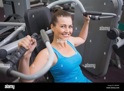 Fit Brunette Using Weights Machine For Arms Stock Photo Alamy