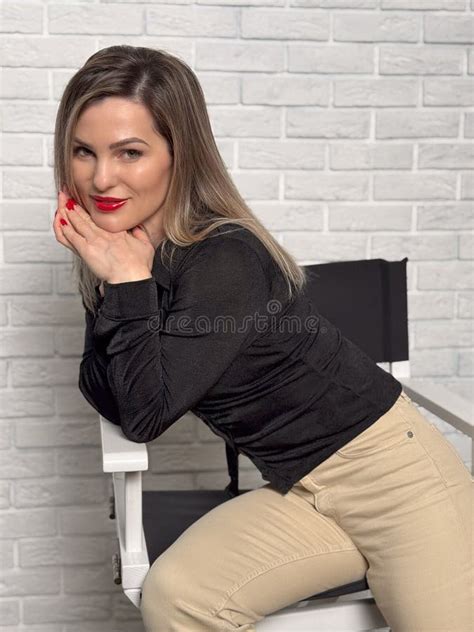 Blonde Fashion Model In Pastel Beige Suit Sitting On Chair Stock Image Image Of Dress Female