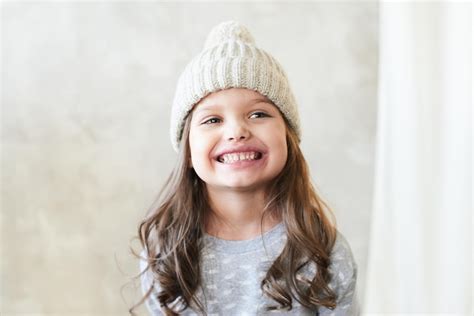 Beautiful smiling little girl in a knitted hat | Premium Photo