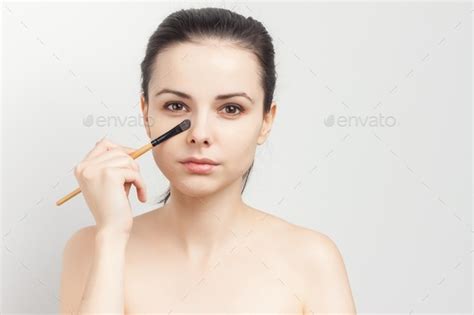 Pretty Brunette Naked Shoulders Brush In Hand Applying Makeup Stock Photo By Shotprime