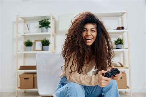 Agradable Bastante Disfrutada La Ganadora Latina Rizada Y Bronceada Sostiene Con Joystick