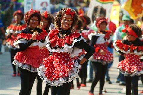 Several Women In Red And White Dresses Are Marching Down The Street