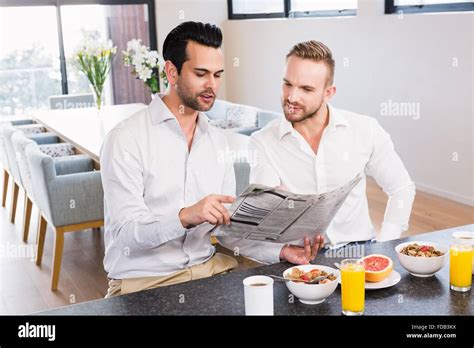 Smiling Gay Couple Reading Newspaper Stock Photo Alamy