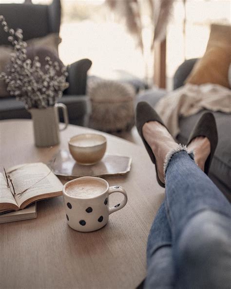 A Person S Feet Resting On A Table With A Cup Of Coffee And An Open Book