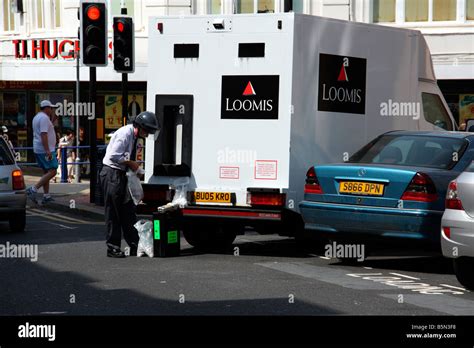 loomis security guard delivering cash  eastbourne east sussex stock
