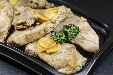 Chicken With Broccoli And Lemon Slices In A Black Tray On A Counter Top