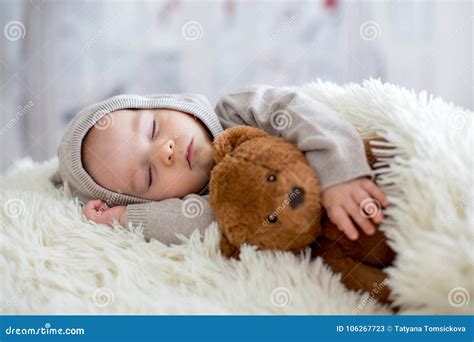 Sweet Baby Boy In Bear Overall Sleeping In Bed With Teddy Bear Stock