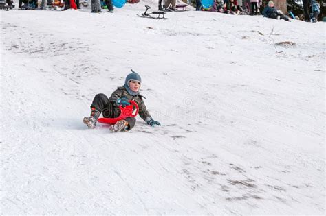 Happy Smiling Boy Sliding Down On Saucer Sled The Hill Is Covered