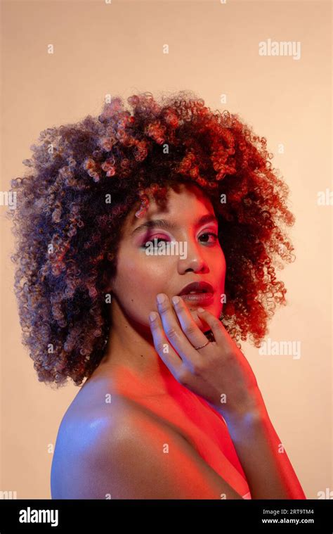 Biracial Woman Wearing Pink Eyeshadow And Lipstick In Red And Blue