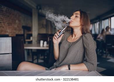 Beautiful Brunette Smoke Electronic Cigarette Public库存照片322138481