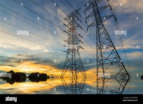 High Voltage Power Transmission Towers In Sunset Sky Background Stock