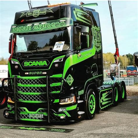 A Green And Black Truck Parked In A Parking Lot