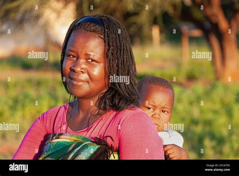 young village african woman with braids holding her baby Stock Photo ...