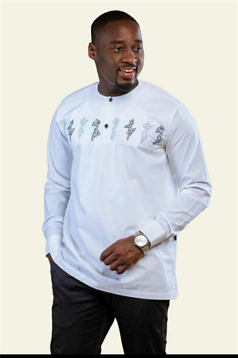 A Man Wearing A White Long Sleeved Shirt With An Embroidered Design On