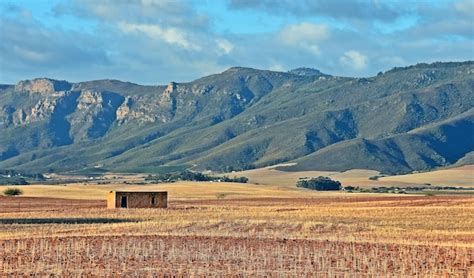 Premium Photo | Landscape with a farm house on dry land and mountains ...