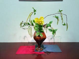 A Vase Filled With Yellow Flowers Sitting On Top Of A Wooden Table Next