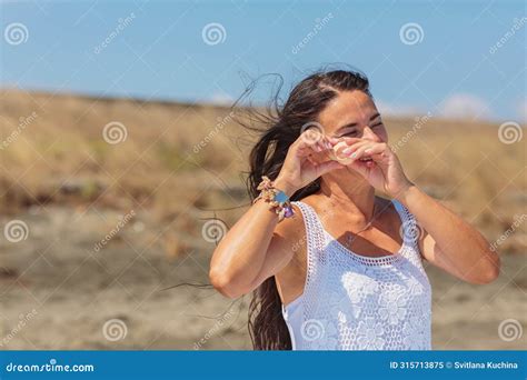 Mature Woman Standing On Beach With Sea Shell And Smiling Stock Image