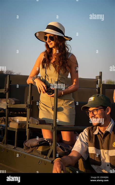 Brunette Kneels In Jeep With Safari Guide Stock Photo Alamy