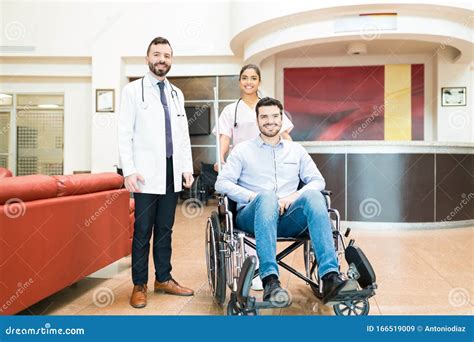 Male And Female Doctors Leaving Recovered Patient From Hospital Stock