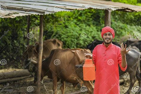 Indian Farmer Holding Milk Bottle In Hand At Dairy Farm Stock Photo