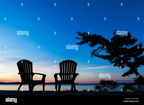 Silhouette Of Muskoka Chairs And Balsam Lake At Sunrise Ontario