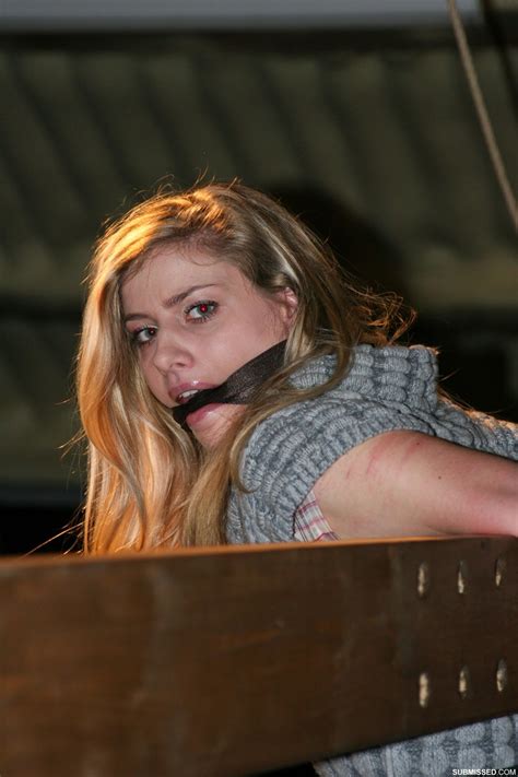 Une jolie blonde se débat contre un bâillon et des cordes alors qu elle est encore habillée