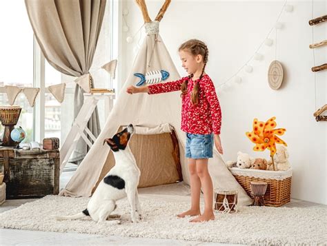 Premium Photo | Girl child training fox terrier dog in light kids room