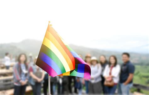 Pride Rainbow Lgbt Gay Flag Holding In Hand And Being Waved In The Breeze Against Blue Sky