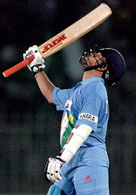 Sachin Tendulkar raises his bat after reaching a century | ESPNcricinfo.com