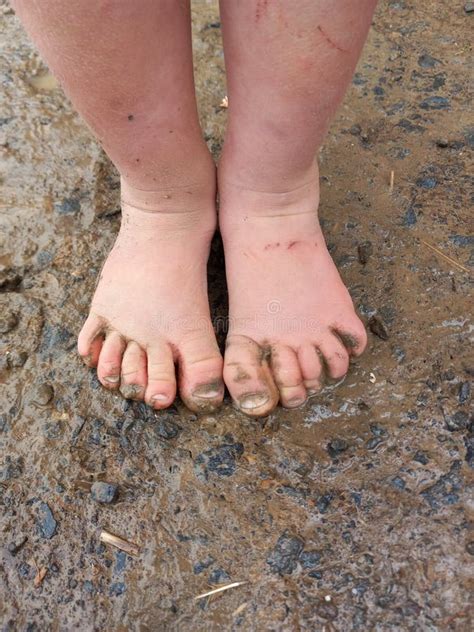 A Child Muddy Feet From Spashing In Puddles After Rain Stock Image