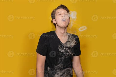 The concept of popularization of vaping. Vaping young man lets out a ...