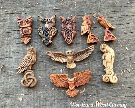 An Assortment Of Carved Wooden Owls Sitting On Top Of A Piece Of Wood