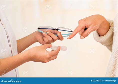 Femalee Doctor Hands Giving Glasses And Contact Lens To Patient