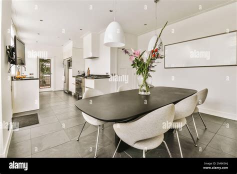 a kitchen and dining area in a house with white walls, grey flooring ...