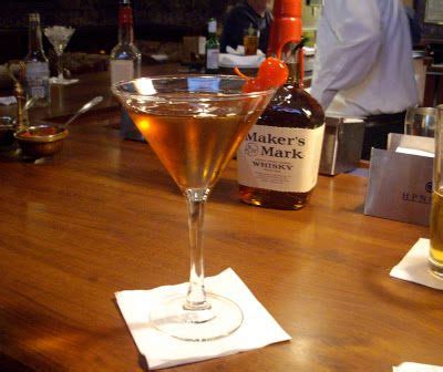 a wooden table topped with two glasses filled with liquid next to ...