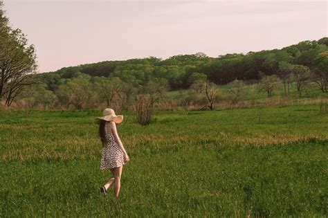 Una Mujer Camina Por Un Campo Con Un Vestido Rosa Y Blanco Y Un