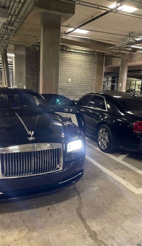 Two Rolls Royces Are Parked In A Parking Garage Next To Each Other On