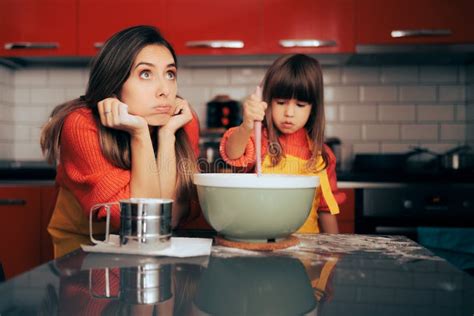 Stressed Mom Supervising Her Daughter In The Kitchen Cooking Stock