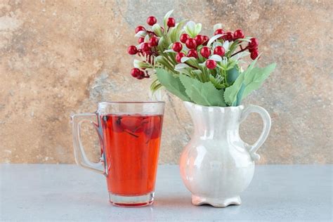 Vaso De Jugo Con Rosa Mosqueta Y Flores Artificiales En El Cuadro Azul